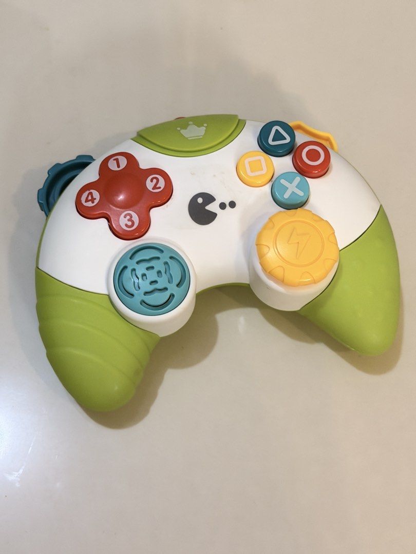 Baby's First Toy Game Controller with Lights and Sounds (Category: Educational & Learning Toys) located in Rizal. Submitted by karlaquijanomd (Listing ID 1461396303, Image 1). Description: - Fun toy game controller for little ones. - Colorful buttons with numbers and shapes. - Features Pac-Man character and a crown. - Makes sounds and lights up when buttons are pressed. - Develops motor skills and sensory exploration. - Perfect for babies and tod