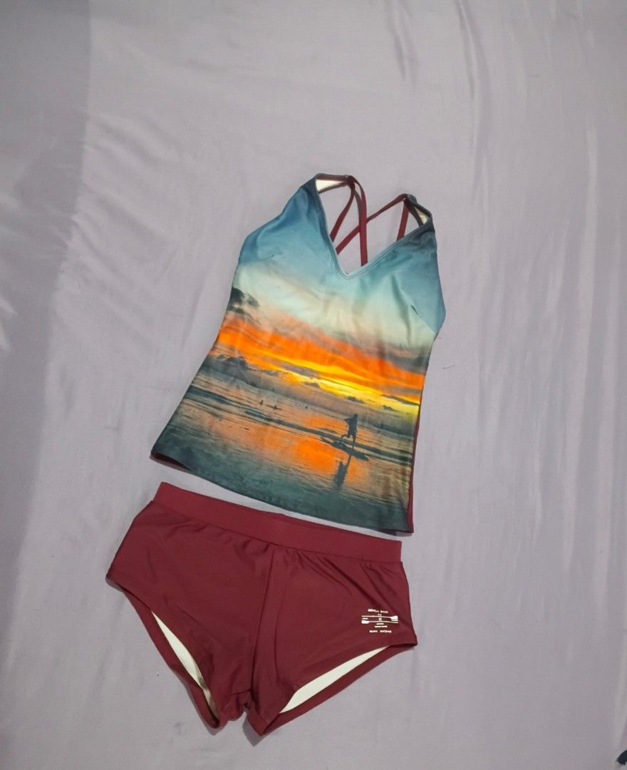 BENCH Beach Sunset Print Tankini & Shorts (Category: Bikinis & Swimsuits) located in Taguig. Submitted by maffieyat (Listing ID 1461488002, Image 1). Description: - Maroon two-piece swimsuit - Tankini top with vibrant beach sunset design - Features a stylish strappy back - Comes with matching maroon shorts - Ideal for swimming and beach activities - Can be used by girls ages 10 and up.