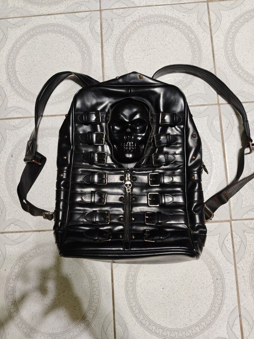 Black Faux Leather Skull Backpack with Buckles (Category: Backpacks) located in Isulan. Submitted by jaysthrift (Listing ID 1461456690, Image 1). Description: Cool black backpack with a skull design on the front. Lots of buckle details. The inside lining has a skull pattern too. Straps are adjustable. Some rust on the metal parts of the straps. Check photos for details. issue: sign of usage scratch and rust.