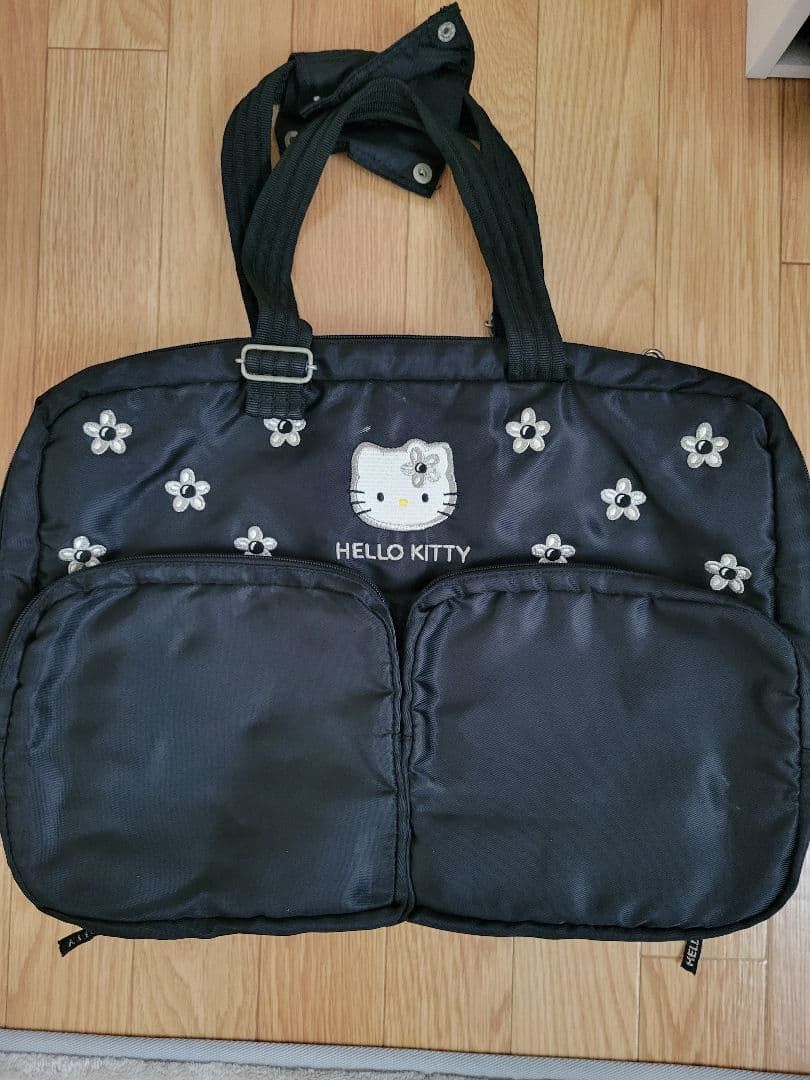 Black Hello Kitty Floral Duffle Bag (Category: Shoulder Bags) located in Manila. Submitted by prelovedshop0818 (Listing ID 1461379871, Image 3). Description: - Cute black duffle bag - Adorable Kitty and floral embroidery - Two convenient front pockets - Spacious main compartment - Interior organization: mesh pockets and a clear zippered section - Ideal for travel or everyday use - Zippers feature exclusive ' Kitty' branding.