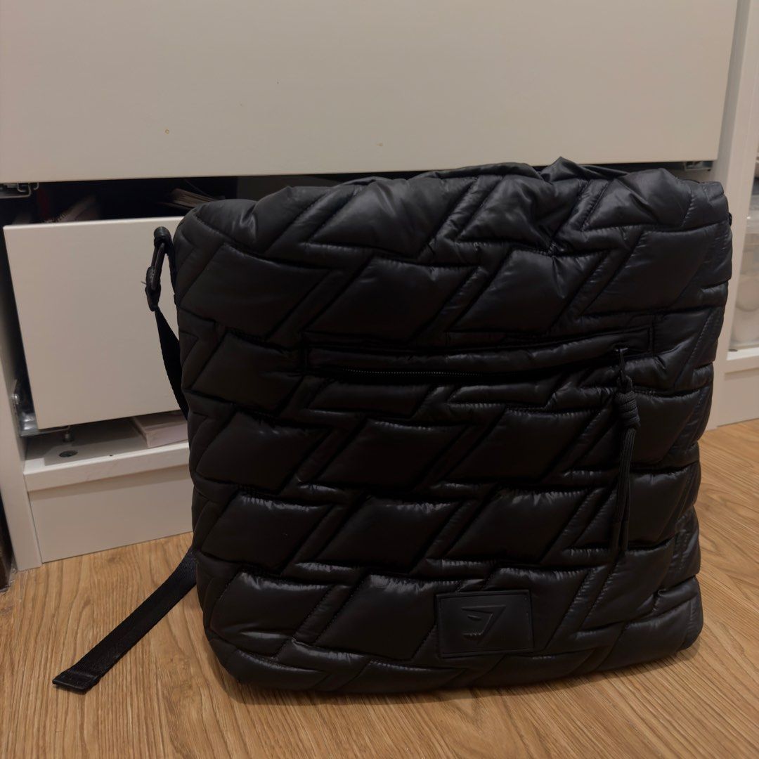 Gymshark Black Puffer Drawstring Gym or Work Bag (Category: Tote Bags) located in Pasig City. Submitted by kndlljnnrx (Listing ID 1461389514, Image 2). Description: - Gymshark chic black puffer bag - Can be used as a work bag or gym bag - Unique geometric stitch pattern - Secure drawstring closure - Adjustable strap - RFS: barely used - SRP is 3k+.