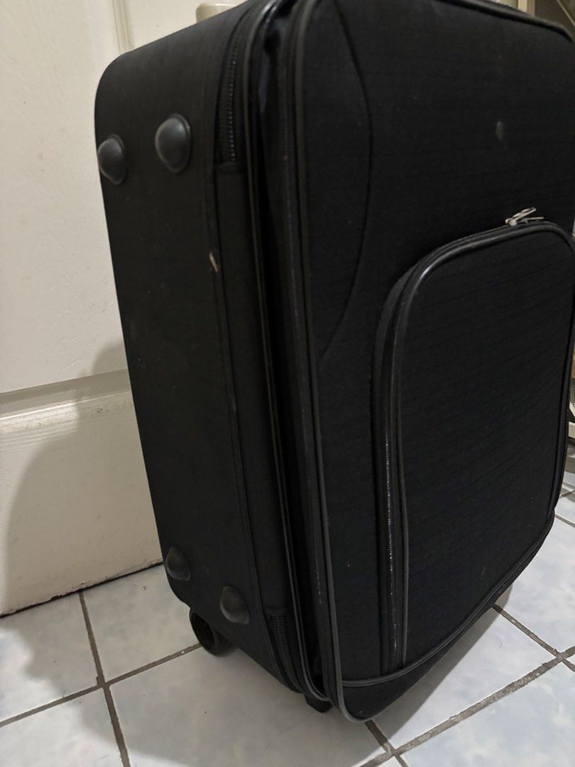 Black Rolling Suitcase (Category: Luggage) located in Mandaluyong City. Submitted by anyadeclutters (Listing ID 1461367329, Image 3). Description: - Black rolling suitcase - Front zippered pocket - Extendable handle and wheels for easy transport - Zippers are broken and need replacement - Needs Cleaning - Minor scuffs on wheels and exterior from normal use.
