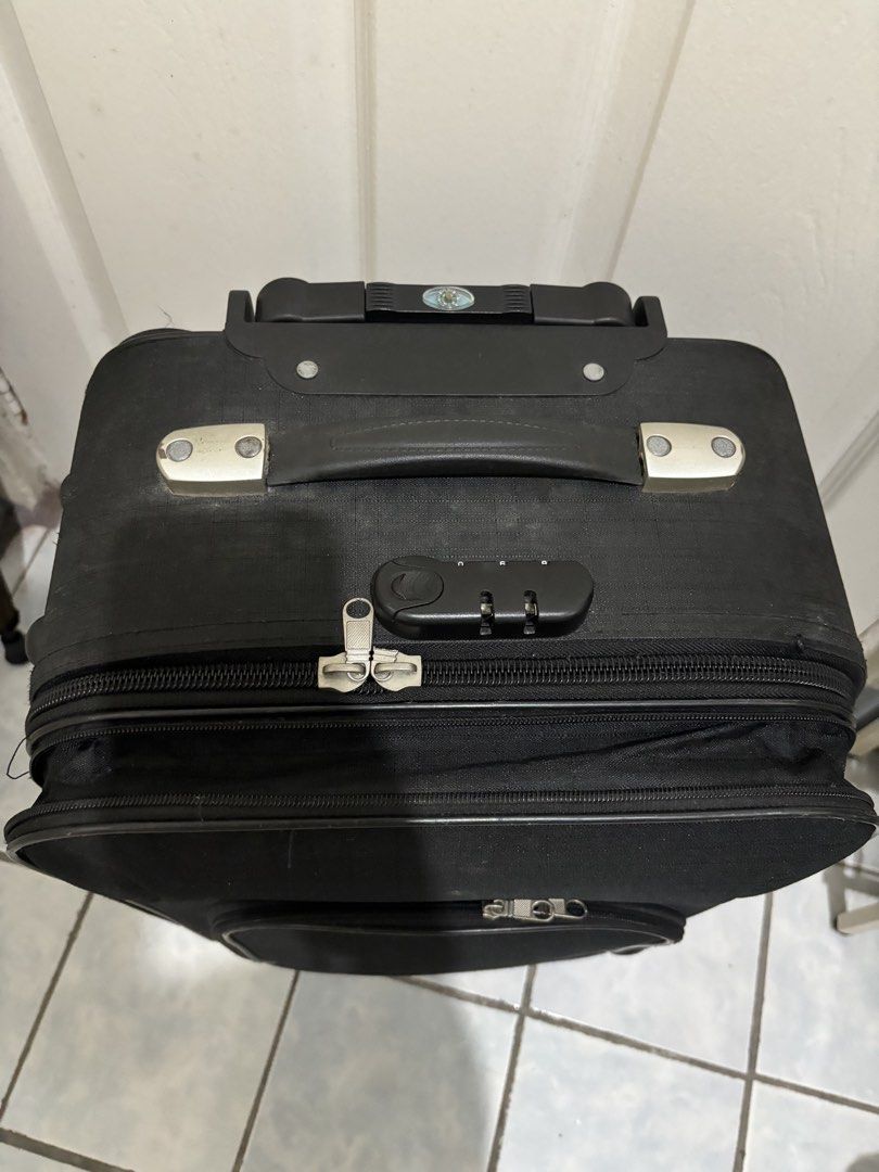 Black Rolling Suitcase (Category: Luggage) located in Mandaluyong City. Submitted by anyadeclutters (Listing ID 1461367329, Image 2). Description: - Black rolling suitcase - Front zippered pocket - Extendable handle and wheels for easy transport - Zippers are broken and need replacement - Needs Cleaning - Minor scuffs on wheels and exterior from normal use.