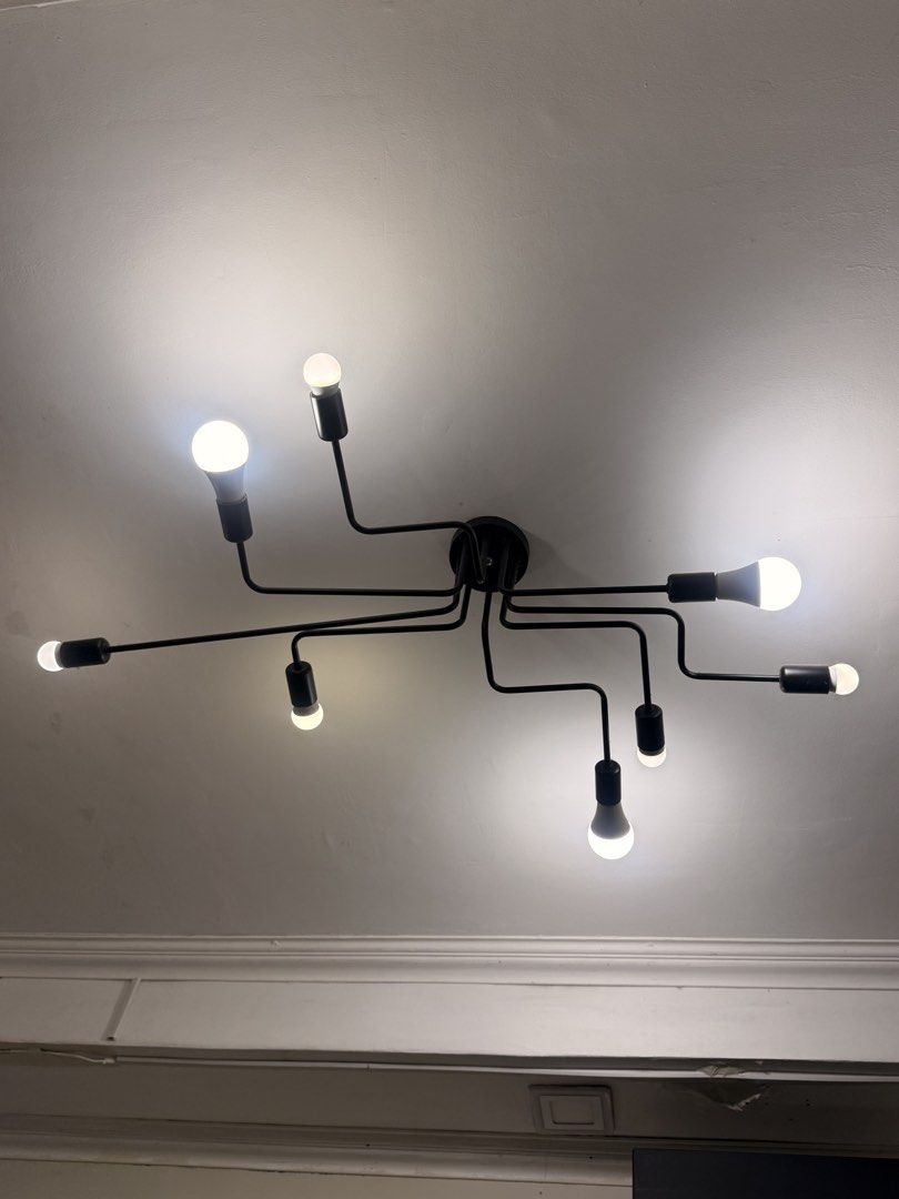 Black Spider Chandelier Ceiling Light Fixture (Category: Lighting) located in Manila. Submitted by mrmarkmarcos.official (Listing ID 1461411359, Image 1). Description: - Modern black spider chandelier - Features 8 arms with exposed bulbs - Creates a unique industrial vibe - Easy installation on standard ceiling mounts - Ideal for living rooms, dining areas, or bedrooms - Bulbs are included.