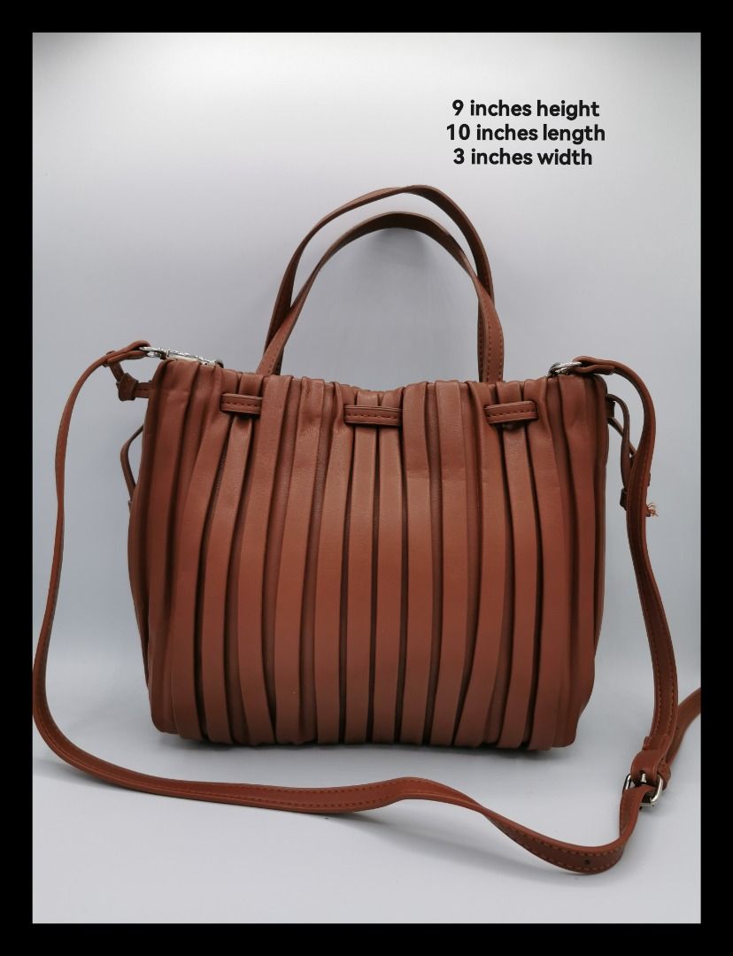 Brown Pleated Leather Handbag with Shoulder Strap (Category: Shoulder Bags) located in Malabon City. Submitted by restrapped88 (Listing ID 1461520507, Image 1). Description: - In great condition. - Cute brown handbag with stylish pleated design. - Made from durable leather. - Comes with comfortable top handles. - Includes a detachable shoulder strap for versatile carrying. - Dimensions: 9 inches (height) x 10 inches (length) x 3 inches (width)..