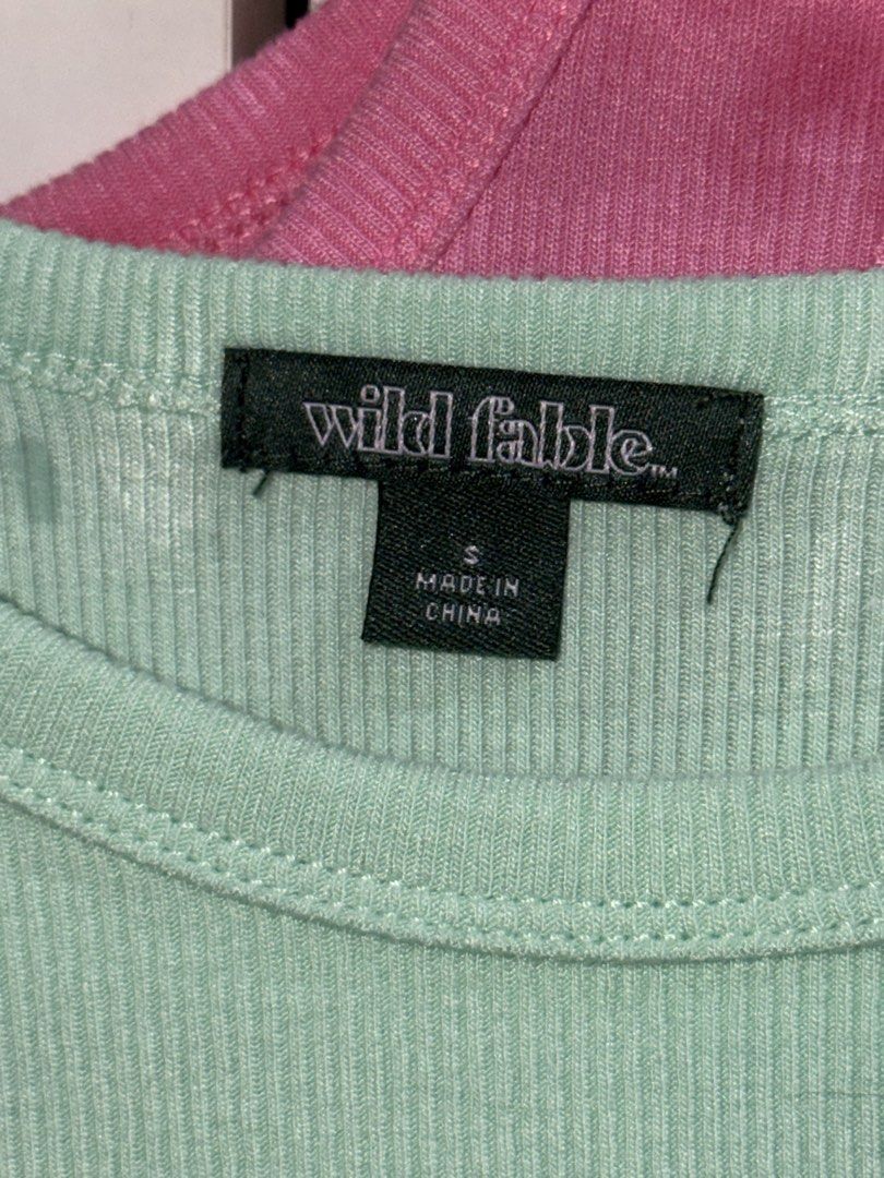 Buy One Get One Wild Fable Top (Category: Sleeveless) located in Manila. Submitted by closetbykiks (Listing ID 1461439245, Image 3). Description: Brand: Wild Fable Size: XX-Small (XXS) Colors Included: Mint Green (Seashell) & Bright Pink (Daisy) Material: Soft, stretchy ribbed knit fabric Style: High crew neck, sleeveless racerback-style tank, fitted silhouette Condition: Brand new / Excellent condition Styling Suggestion: Layer them together for