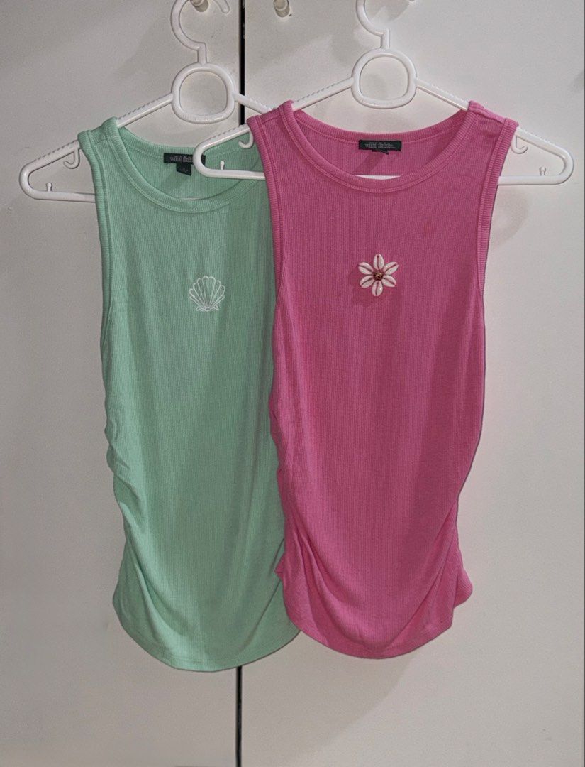 Buy One Get One Wild Fable Top (Category: Sleeveless) located in Manila. Submitted by closetbykiks (Listing ID 1461439245, Image 2). Description: Brand: Wild Fable Size: XX-Small (XXS) Colors Included: Mint Green (Seashell) & Bright Pink (Daisy) Material: Soft, stretchy ribbed knit fabric Style: High crew neck, sleeveless racerback-style tank, fitted silhouette Condition: Brand new / Excellent condition Styling Suggestion: Layer them together for