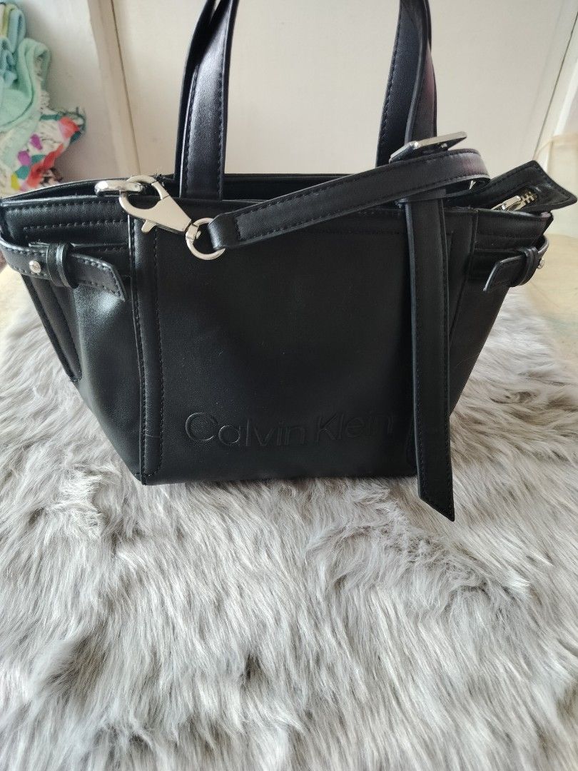 Calvin Klein Black Leather body bag (Category: Cross-body Bags) located in Manila. Submitted by bushe027 (Listing ID 1461398806, Image 2). Description: - Genuine black leather Calvin klein cross body bag - Versatile top handles and detachable shoulder strap - Elegant embossed logo on the front - Timeless, simple design suitable for everyday wear.