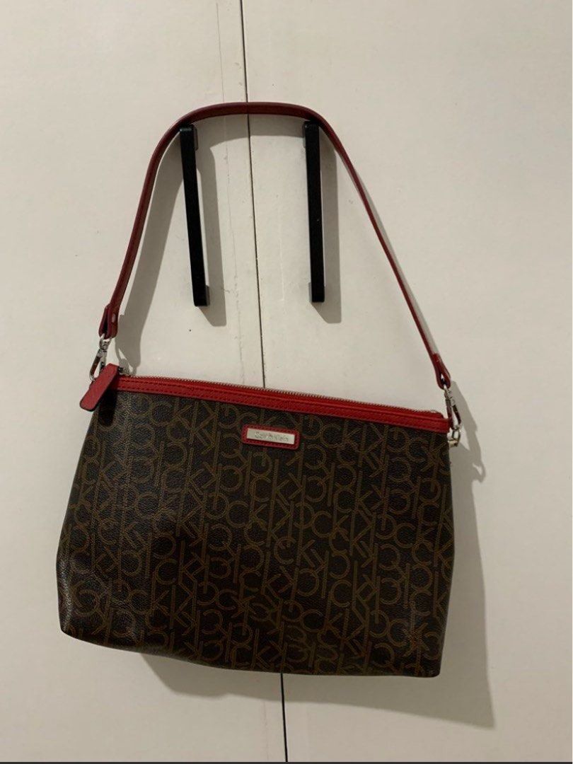 Calvin Klein Monogram Shoulder Bag with Red Trim (Category: Shoulder Bags) located in Quezon City. Submitted by artsymabel (Listing ID 1461338374, Image 1). Description: - Brown Calvin Klein shoulder bag - All-over CK monogram print - Red trim and strap details - Zipper closure - Interior zippered pocket and slip pocket - Clean interior - Perfect for everyday use.
