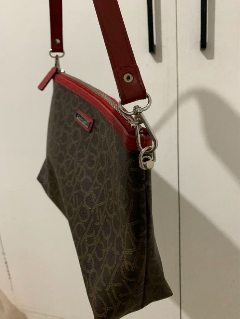 Calvin Klein Monogram Shoulder Bag with Red Trim (Category: Shoulder Bags) located in Quezon City. Submitted by artsymabel (Listing ID 1461338374, Image 3). Description: - Brown Calvin Klein shoulder bag - All-over CK monogram print - Red trim and strap details - Zipper closure - Interior zippered pocket and slip pocket - Clean interior - Perfect for everyday use.