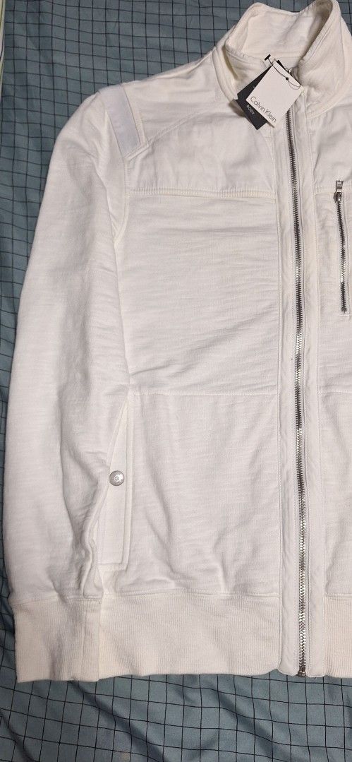 Calvin Klein White Zip-Up Jacket (Category: Coats, Jackets and Outerwear) located in Manila. Submitted by ags028705 (Listing ID 1460916300, Image 2). Description: - Brand new Calvin Klein white jacket - Size XS/TP - Full zip closure - Zipped chest pocket - Buttoned flap pockets - Ribbed cuffs and hem - Tag still attached.