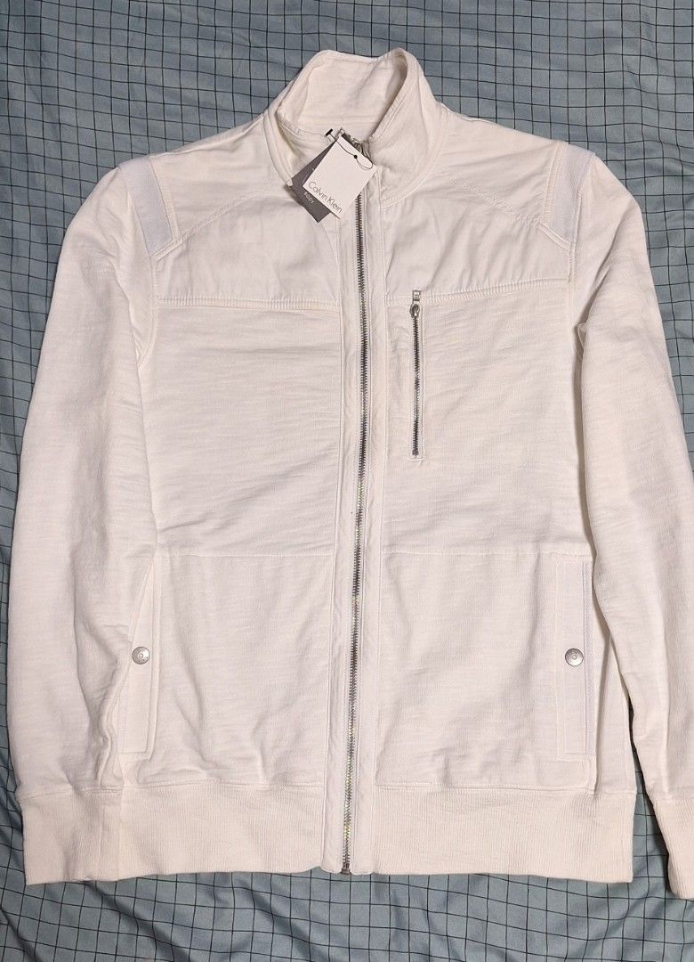 Calvin Klein White Zip-Up Jacket (Category: Coats, Jackets and Outerwear) located in Manila. Submitted by ags028705 (Listing ID 1460916300, Image 1). Description: - Brand new Calvin Klein white jacket - Size XS/TP - Full zip closure - Zipped chest pocket - Buttoned flap pockets - Ribbed cuffs and hem - Tag still attached.