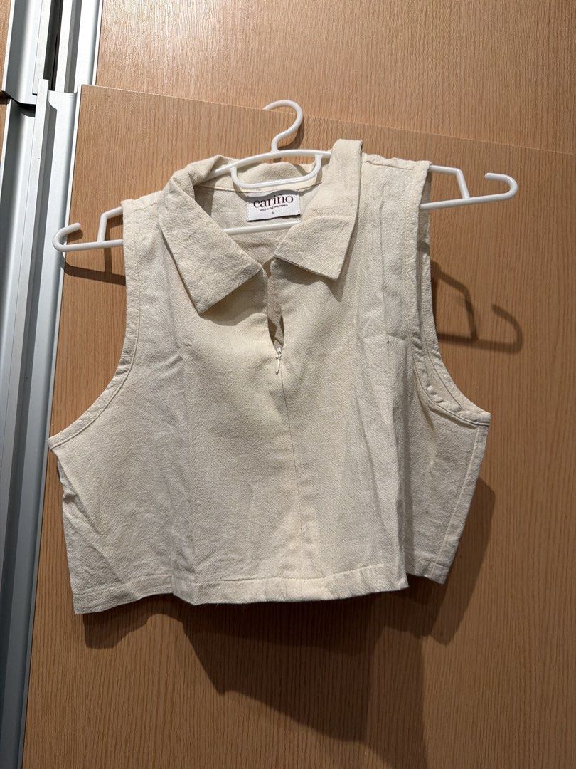 Carino Sleeveless Collared Zip-Up Crop Top (Category: Sleeveless) located in Taguig. Submitted by gabgabie (Listing ID 1461493439, Image 1). Description: - Cream sleeveless crop top - Brand: Carino - Collared neckline with zip-up detail - Estimated size: S - Made in the Philippines - Ideal for casual wear or layering.