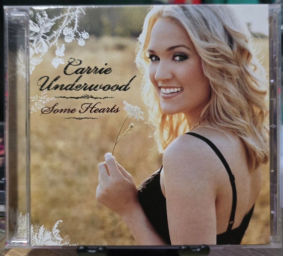 Carrie Underwood Some Hearts CD (Category: CDs & DVDs) located in Pasig City. Submitted by just.mel86 (Listing ID 1461512452, Image 1). Description: - Carrie Underwood's 'Some Hearts' album on CD. - Features her popular hit songs. - Ideal for country music enthusiasts. - Comes in a clear plastic CD case. - Album cover: Carrie Underwood smiling with a white flower against a golden field background..