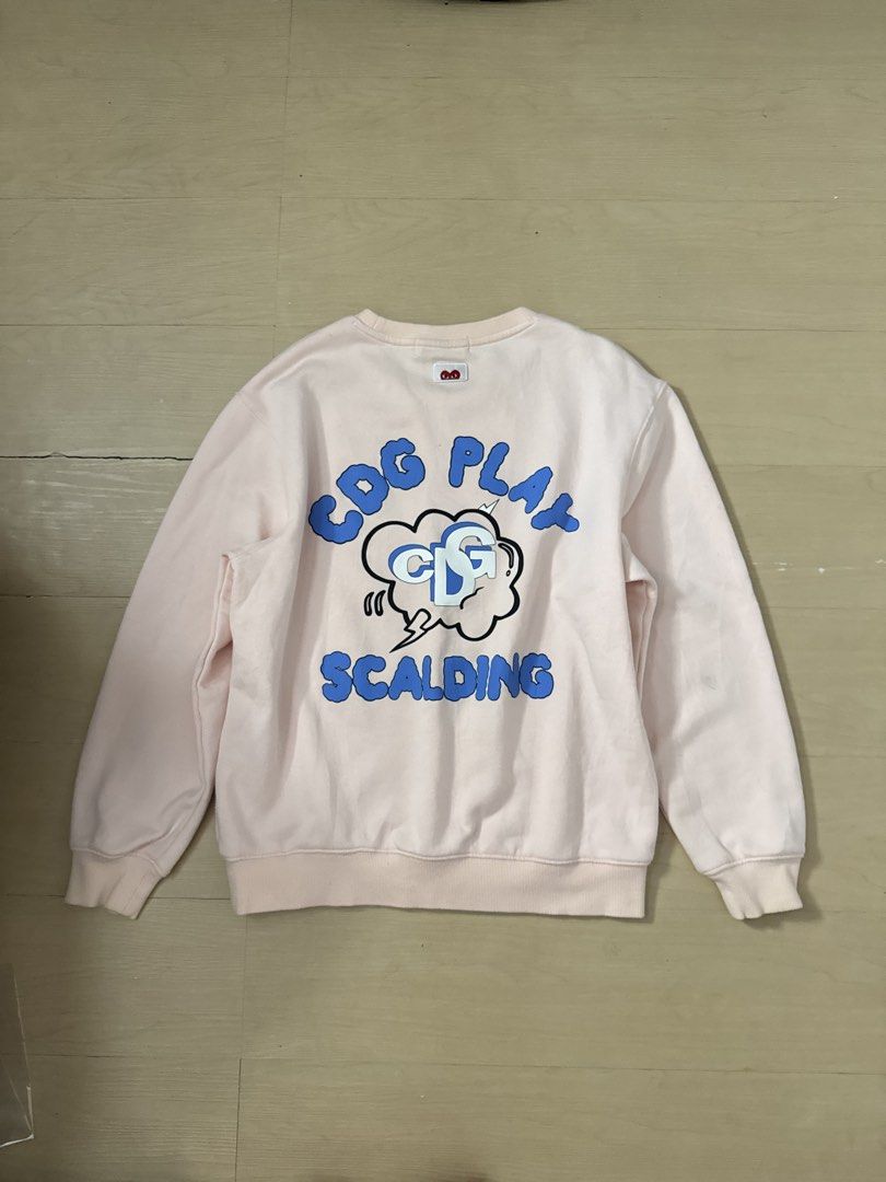CDG PLAY Sweater (Category: Longsleeves) located in Manila. Submitted by juhjuh (Listing ID 1461380443, Image 3). Description: - Authentic Pink CDG PLAY Sweatshirt - Iconic heart logo on the front - Large 'CDG PLAY SCALDING' graphic print on the back - Classic crew neck and long sleeves - Comfortable and stylish for everyday wear - Good as new .