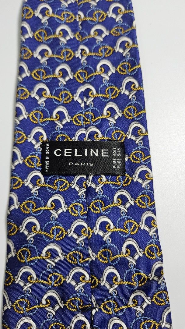 Celine Paris Pure Silk Tie Made in Spain (Category: Ties) located in Alfonso. Submitted by jbcamet (Listing ID 1461492986, Image 3). Description: - Authentic Celine Paris tie - 100% pure silk - Navy blue base with repeating gold, white, and blue horseshoe and rope motifs - Crafted in Spain - Perfect for formal or business occasions.
