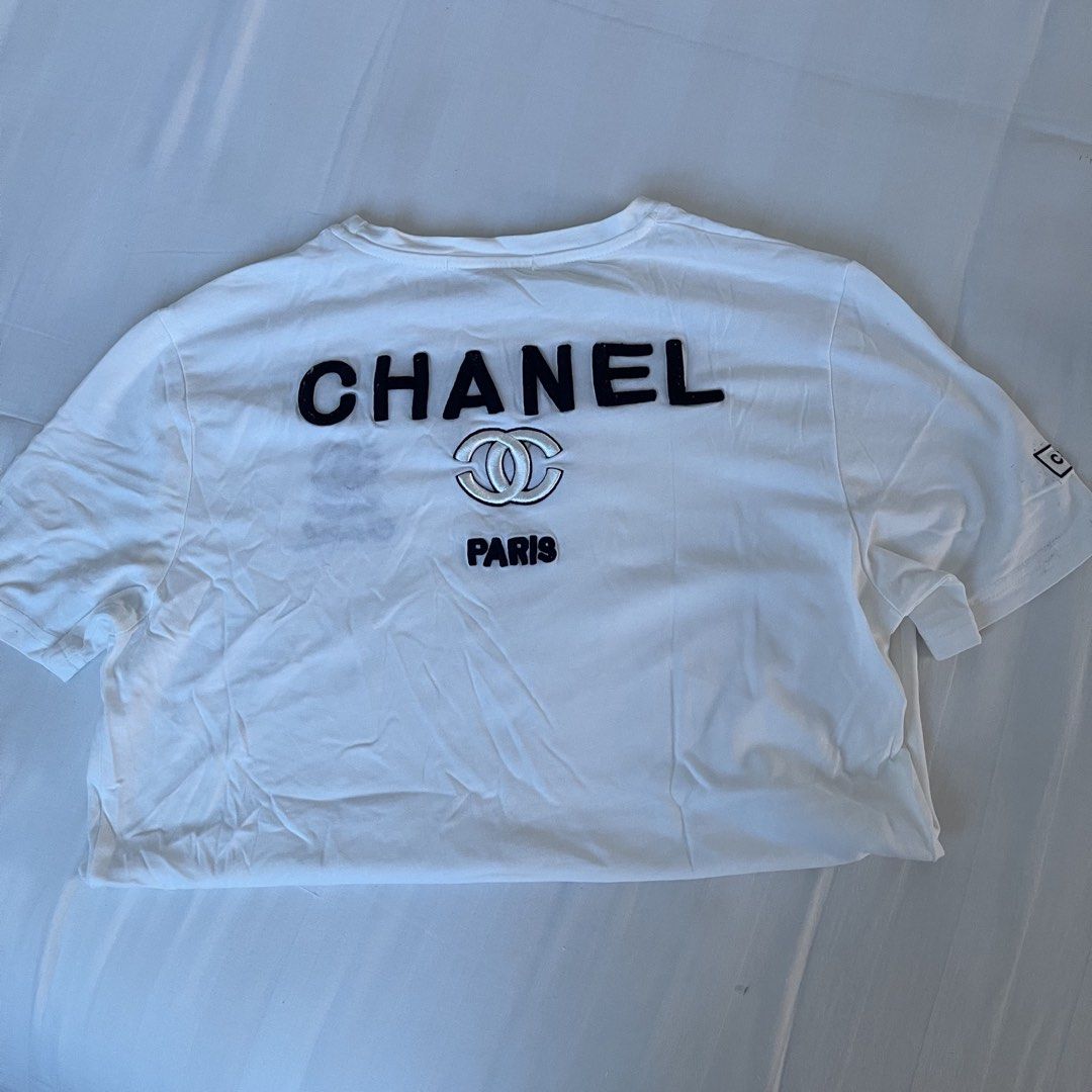 Chanel Paris White T-Shirt (Category: Shirts) located in Muntinlupa City. Submitted by sza1123 (Listing ID 1461404827, Image 2). Description: - Authentic Chanel t-shirt - Classic white color - 'Chanel Paris' graphic on the back - Small 'Coco Chanel' logo on the front left chest - Short sleeves - Estimated size: Medium - Ideal for everyday, casual styling.