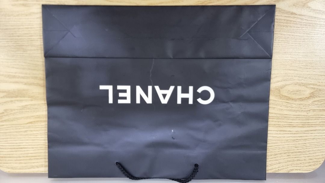 Chanel Shopping Bag (Category: Luxury Bags & Wallets) located in Paranaque City. Submitted by olxph_668280920 (Listing ID 1461473156, Image 2). Description: - Authentic Chanel shopping bag - Color: Black with white Chanel logo - Approximate Dimensions: 11 x 11 x 4 inches - Features black ribbon handles - Ideal for shopping or as a gift bag - Condition: Good.