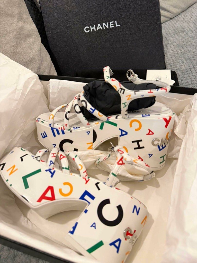 Chanel White Multicolor Logo Platform Sandals (Category: Sneakers & Footwear) located in Makati City. Submitted by dee_online888 (Listing ID 1461412990, Image 1). Description: - Authentic Chanel platform sandals - Eye-catching multicolor logo print on white base - Secure ankle strap closure - Comes with original box and dust bag - Substantial heel height for a dramatic effect - Ideal for making a bold fashion statement.
