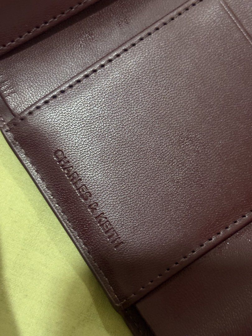 Charles & Keith Burgundy Textured Wallet (Category: Wallets & Card holders) located in Agoo. Submitted by _i6jelly (Listing ID 1461329063, Image 2). Description: - Burgundy textured wallet from Charles & Keith - Secure snap button closure - Interior: Card slots and zippered compartment - Minor wear on magnetic snap closure and zipper pull (functional) - Ideal for organizing your essentials.