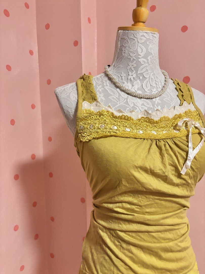 CLEF DE SOL Yellow Lace Trim Tank Top (Category: Sleeveless) located in Pagadian. Submitted by purewonderofsparkles (Listing ID 1461333463, Image 2). Description: - Yellow tank top from CLEF DE SOL - Features delicate lace trim along the neckline and hem - Adorable small ribbon detail on the front - Stylish ruched detailing on the sides - Comfortable and cute for everyday casual wear.