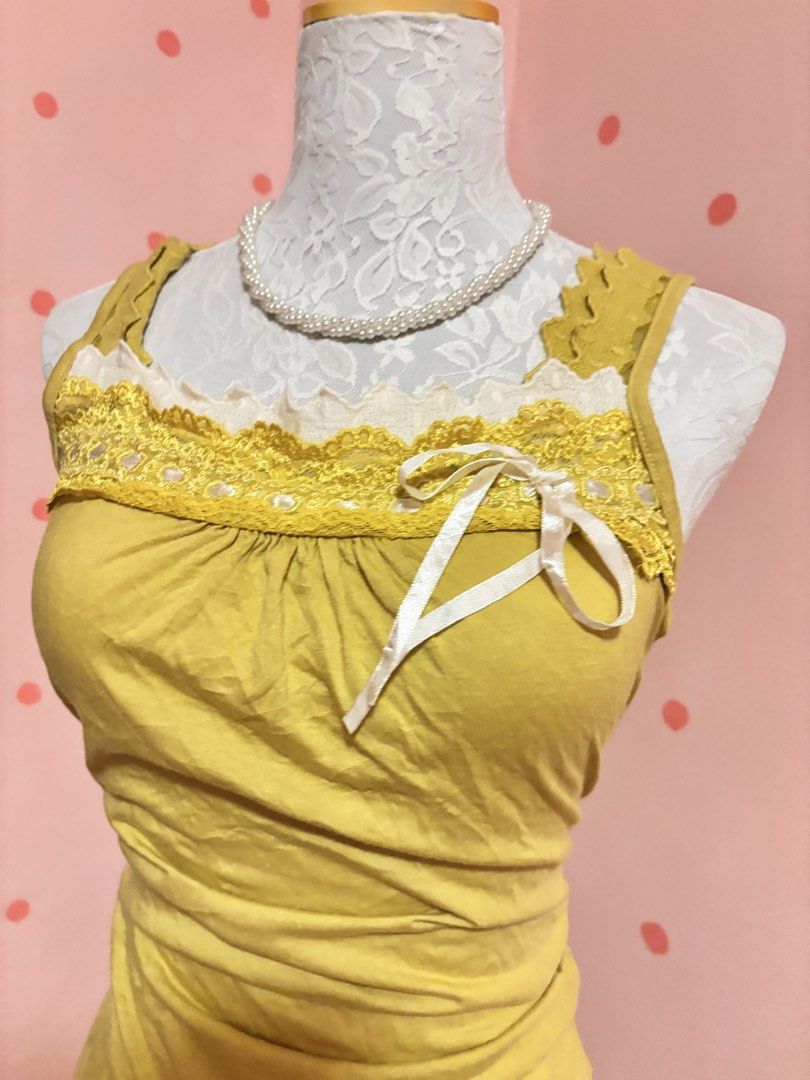 CLEF DE SOL Yellow Lace Trim Tank Top (Category: Sleeveless) located in Pagadian. Submitted by purewonderofsparkles (Listing ID 1461333463, Image 3). Description: - Yellow tank top from CLEF DE SOL - Features delicate lace trim along the neckline and hem - Adorable small ribbon detail on the front - Stylish ruched detailing on the sides - Comfortable and cute for everyday casual wear.