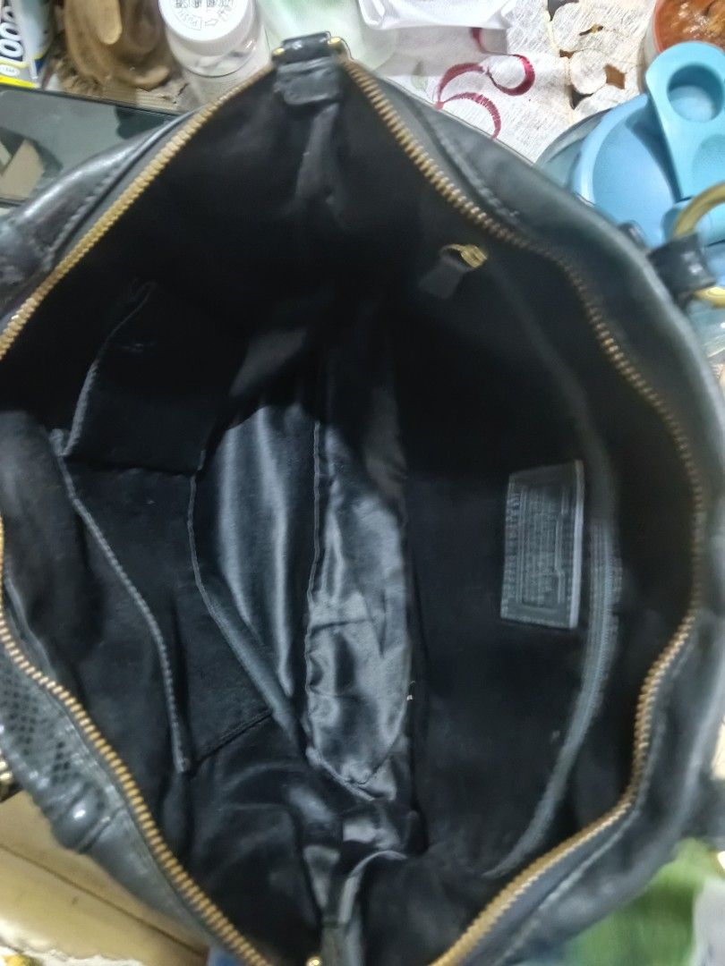 Coach Black Leather Handbag (Category: Luxury Bags & Wallets) located in Quezon City. Submitted by bshoppe_ (Listing ID 1461345770, Image 3). Description: - Genuine black leather Coach handbag - Textured detail on the front flap - Secure zipper closure - Multiple interior compartments and pockets for organization - Leather straps with textured detail - Elegant gold hardware - Ideal for everyday use.