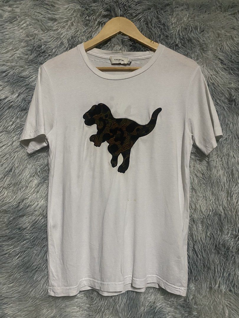 COACH DINOSAUR (Category: Tshirts & Polo Shirts ) located in Cavite. Submitted by lwrnc.444 (Listing ID 1461509074, Image 1). Description: COACH DINOSAUR COMPLETE TAGS GOOD CONDITION/YELLOW STAIN,1 VERY MINIMAL REPAIR HOLE DIMES WIDTH 18.5-19 LENGTH 26 🏷️299+SHIPPING FEE DASMARIÑAS CAVITE LOC.