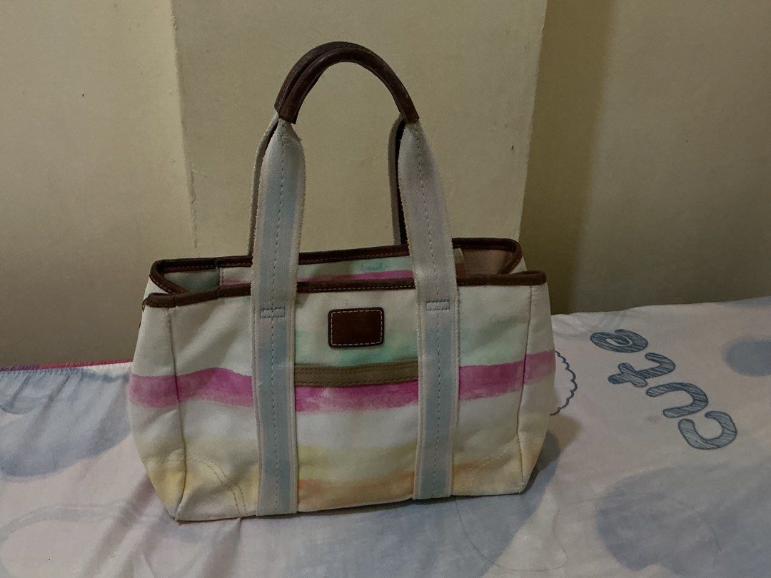 Coach Hampton Canvas Striped Tote Bag (Category: Luxury Bags & Wallets) located in Quezon. Submitted by whimsycart (Listing ID 1461455726, Image 3). Description: - Cute Coach tote bag - Colorful stripe design - Durable canvas material with leather trim and handles - Ideal for everyday use - Features an interior zipper pocket - Shows some signs of wear, but plenty of life left - Perfect size for carrying essentials medj faded color lang huhu + may