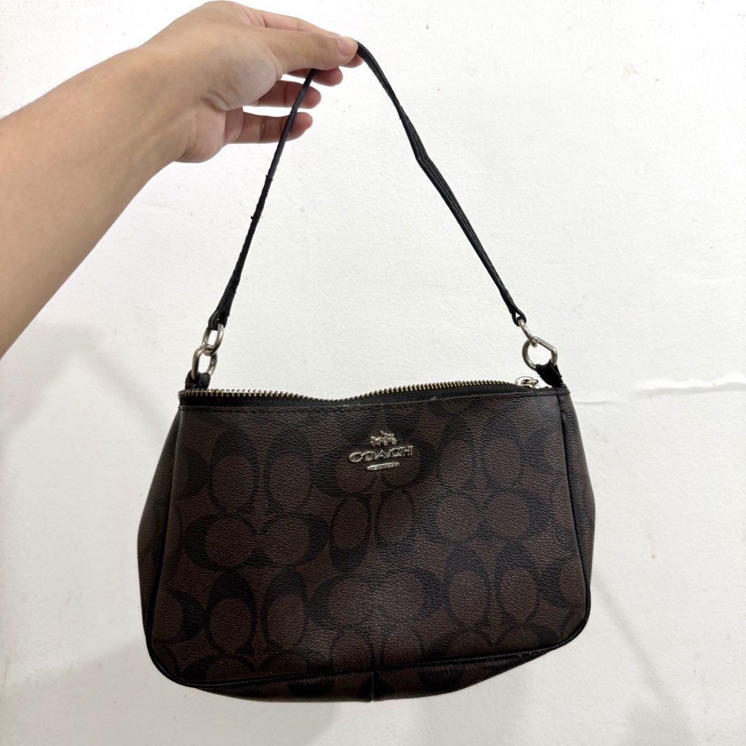 Coach Monogram Canvas Handbag (Category: Shoulder Bags) located in Baguio. Submitted by _jaiiii (Listing ID 1461512469, Image 1). Description: - Authentic Coach monogram canvas wristlet - Zipper closure - Small attached strap - Interior Coach branding tag - Minor signs of wear on strap and zipper edges - Ideal for carrying essentials.