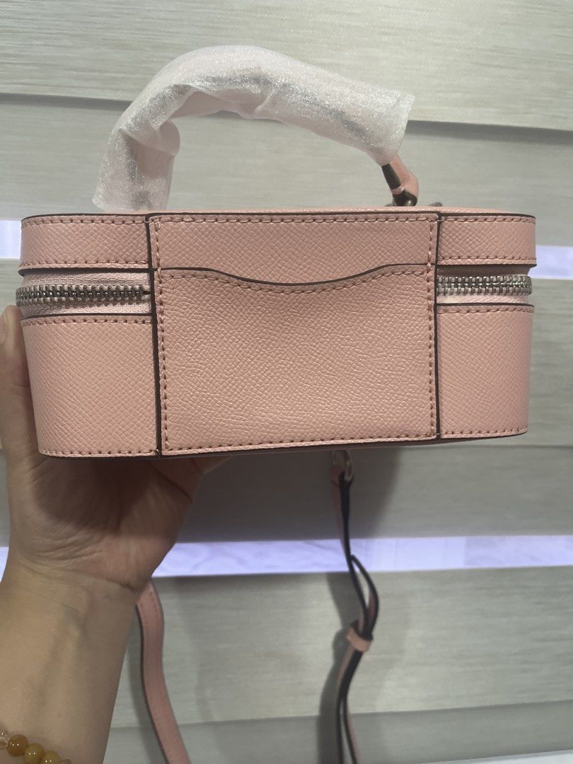 Coach Pink Leather Vanity Case Bag with Chain Strap (Category: Cross-body Bags) located in Pasig City. Submitted by melaiski28 (Listing ID 1461330964, Image 3). Description: - Cute pink Coach vanity case bag - Textured leather - Top handle and detachable chain strap - Spacious interior with zip closure - Ideal for makeup or small essentials - Silver hardware details - Approximately 7 inches long.