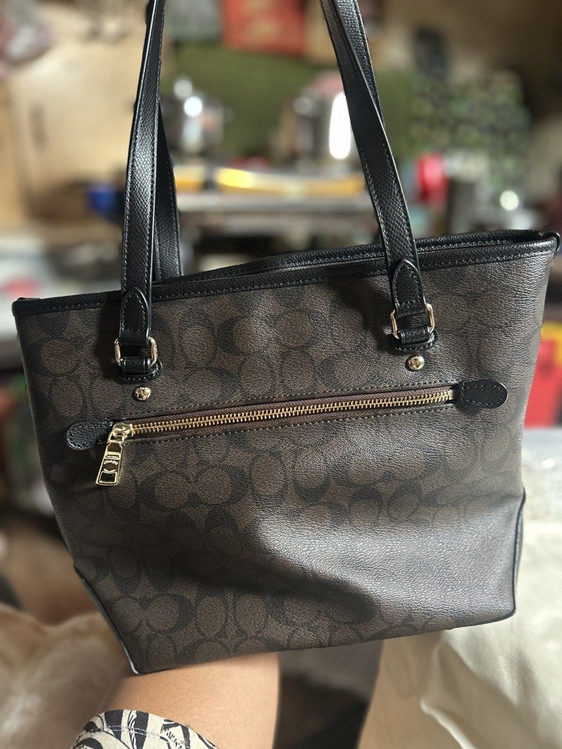 Coach Signature Brown Monogram Tote Bag (Category: Luxury Bags & Wallets) located in Manila. Submitted by evangelist40527 (Listing ID 1461560425, Image 3). Description: - Classic Coach tote bag in signature brown monogram - Black leather trim and handles - Secure zipper closure on top - Multiple interior pockets for organization - Elegant gold-tone hardware - Ideal everyday bag for your essentials.
