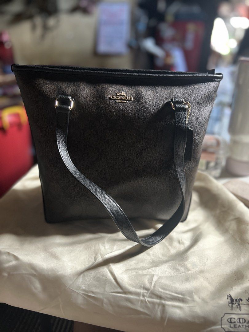 Coach Signature Brown Monogram Tote Bag (Category: Luxury Bags & Wallets) located in Manila. Submitted by evangelist40527 (Listing ID 1461560425, Image 1). Description: - Classic Coach tote bag in signature brown monogram - Black leather trim and handles - Secure zipper closure on top - Multiple interior pockets for organization - Elegant gold-tone hardware - Ideal everyday bag for your essentials.