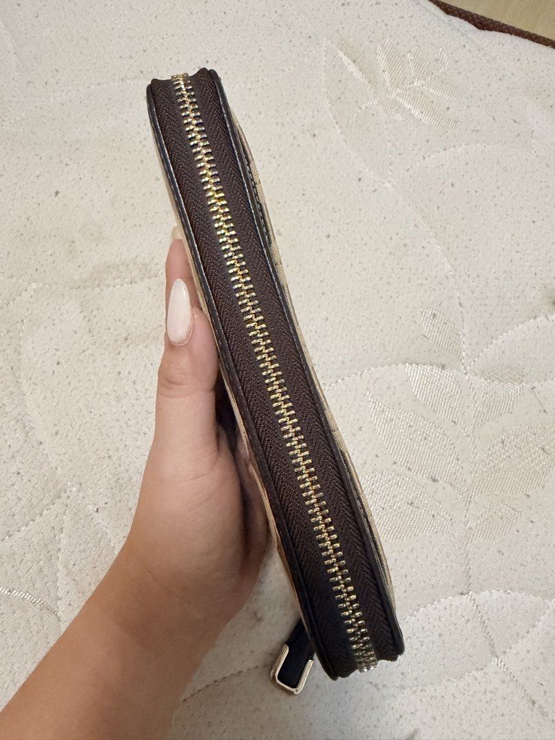 Coach Signature C Monogram Zip Around Wallet (Category: Luxury Bags & Wallets) located in Valenzuela. Submitted by itsmelissamd (Listing ID 1461358396, Image 3). Description: - Authentic Coach wallet - Signature C monogram pattern - Brown leather trim - Gold hardware - Secure zip-around closure - Multiple interior compartments for cards and cash - Zippered coin pocket - Ideal for everyday use.