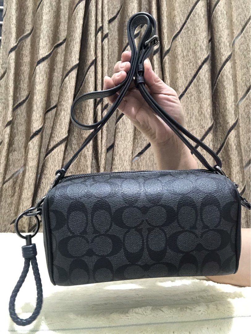 Coach Signature Monogram Barrel Bag (Category: Luxury Bags & Wallets) located in Rizal. Submitted by elviedc2420209 (Listing ID 1461508016, Image 1). Description: - Authentic Coach barrel bag in black signature print. - Features elegant leather trim and strap. - Secure zipper closure. - Includes a detachable wrist strap for versatility. - Can be worn as a crossbody or shoulder bag. - Ample interior space for your daily essentials. - Perfect for e