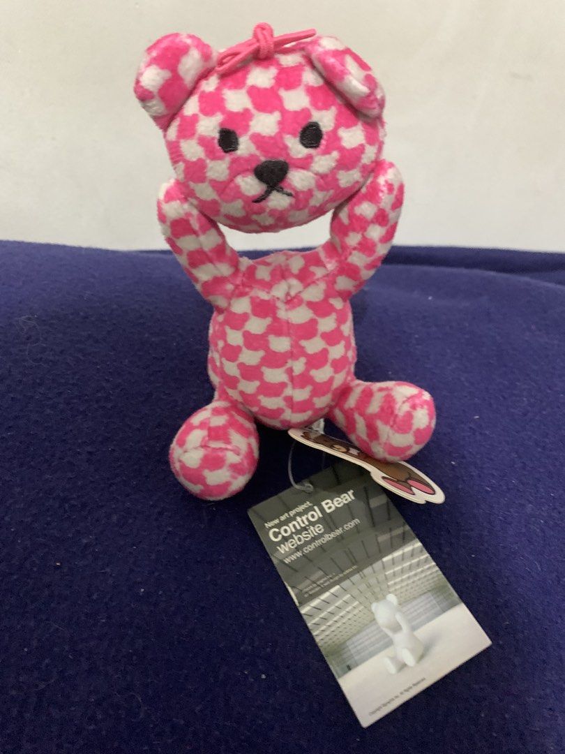 Control Bear Pink White Checkered Plush Toy Keychain (Category: Plushies & Soft Toys) located in Pasig City. Submitted by miswatamita (Listing ID 1461409788, Image 1). Description: - Adorable pink and white checkered plush bear - Features a cute bow on its head - Arms are in an 'up' pose - Comes with a 'Control Bear' tag and website - Ideal for use as a keychain or a small collectible - A must-have for fans of the Control Bear project.