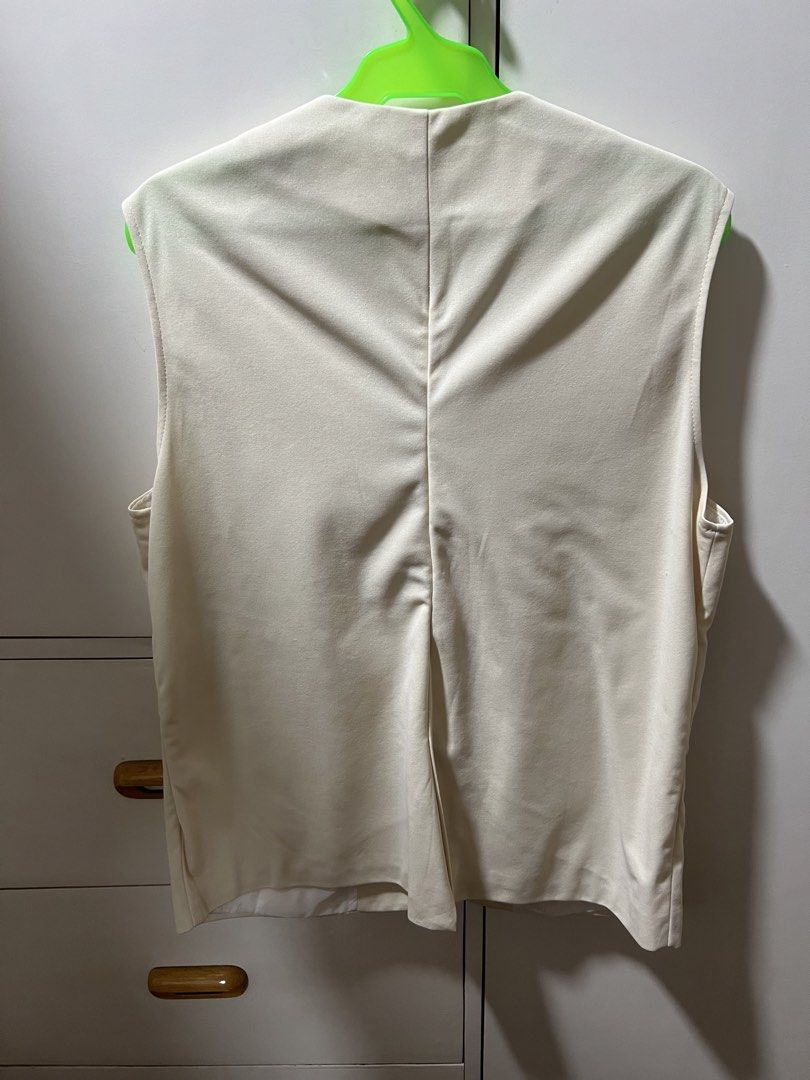 Cream Sleeveless Vest with Button and Pockets (Category: Sleeveless) located in Calamba. Submitted by cdg02 (Listing ID 1461434045, Image 2). Description: - Cream colored sleeveless vest - Two flap pockets on the lower front - Fully lined interior - Versatile for layering over shirts or dresses.