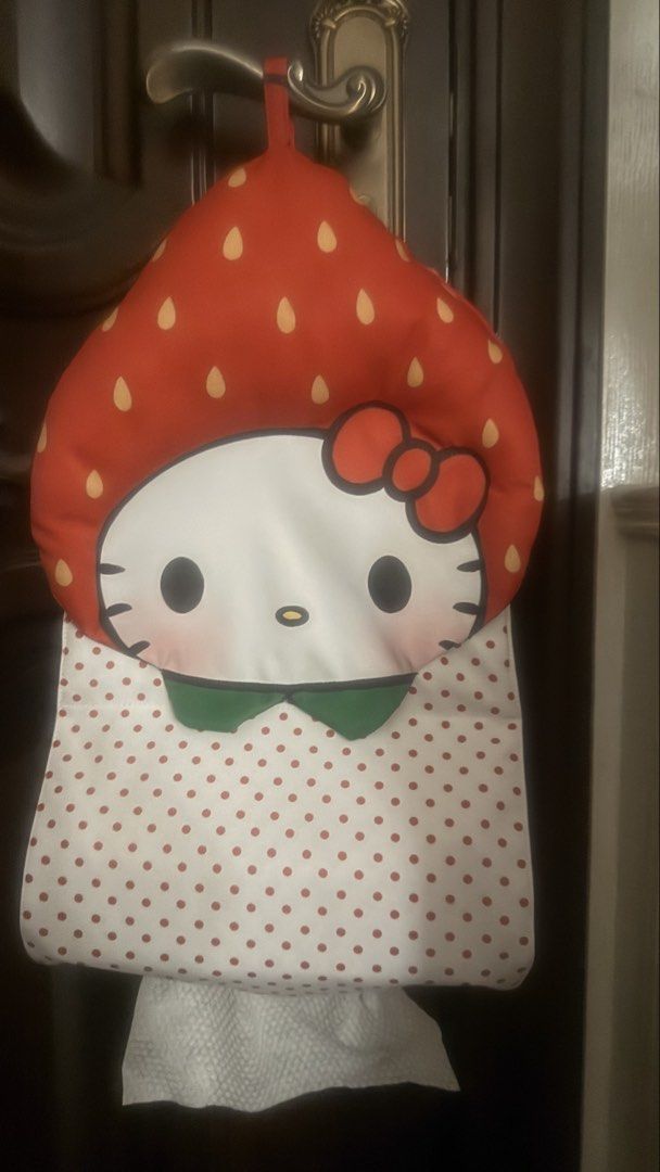 Cute Hello Kitty Strawberry Tissue Holder (Category: Character Goods) located in Manila. Submitted by zz93305 (Listing ID 1461540095, Image 2). Description: - Adorable Hello Kitty tissue holder shaped like a strawberry. - Perfect for hanging on doors or walls. - Features Hello Kitty's face with a red bow and a polka dot body. - Holds a roll of tissues at the bottom. - Adds a cute touch to any room. - Approximately 15 inches long..
