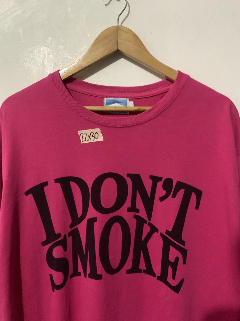 Donsmoke "I DON'T SMOKE" Graphic Tee (Category: Tshirts & Polo Shirts ) located in Manila. Submitted by tanjames.14 (Listing ID 1461445575, Image 2). Description: - Pink graphic tee from Donsmoke - Features bold "I DON'T SMOKE" slogan - Made from 100% cotton - Tagged size L - Care instructions available on label - Perfect statement piece.