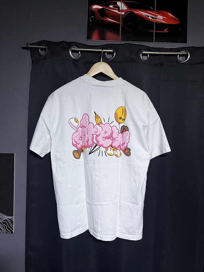 Drew House White T-Shirt Size M (Category: Tshirts & Polo Shirts ) located in Panabo. Submitted by edition_25 (Listing ID 1461540200, Image 2). Description: - White Drew House T-shirt - Iconic 'drew' logo on front left chest - Fun graphic print with clouds and characters on the back - Size: Medium (M) - Made in Vietnam - Ideal for casual everyday wear - 22 width - 30 length - As new condition .