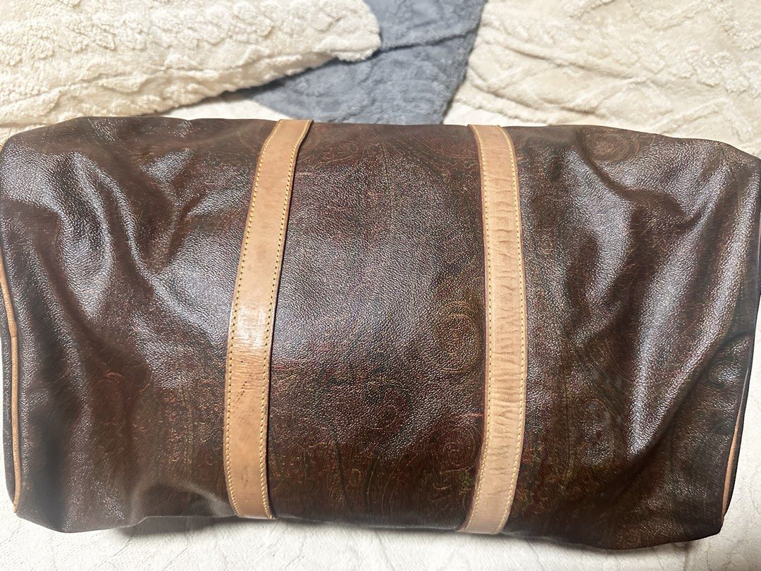 ETRO Milano Duffel Bag (Category: Luxury Bags & Wallets) located in Makati City. Submitted by travel.pasabuy (Listing ID 1461532954, Image 2). Description: - Classic Authentic ETRO duffel bag - Iconic paisley print on dark brown background - Leather trim and handles (shows some wear) - Functional zippers - Includes colorful letter keychain - Ideal for weekend trips or stylish carry-on.