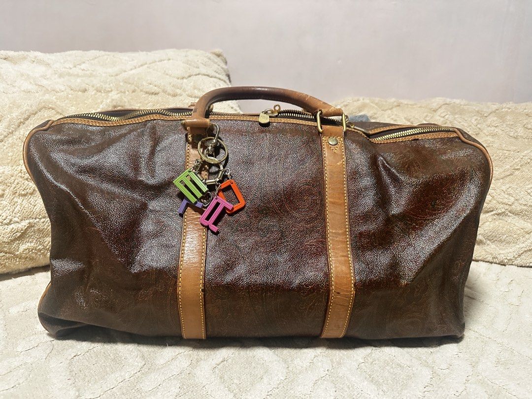 ETRO Milano Duffel Bag (Category: Luxury Bags & Wallets) located in Makati City. Submitted by travel.pasabuy (Listing ID 1461532954, Image 1). Description: - Classic Authentic ETRO duffel bag - Iconic paisley print on dark brown background - Leather trim and handles (shows some wear) - Functional zippers - Includes colorful letter keychain - Ideal for weekend trips or stylish carry-on.
