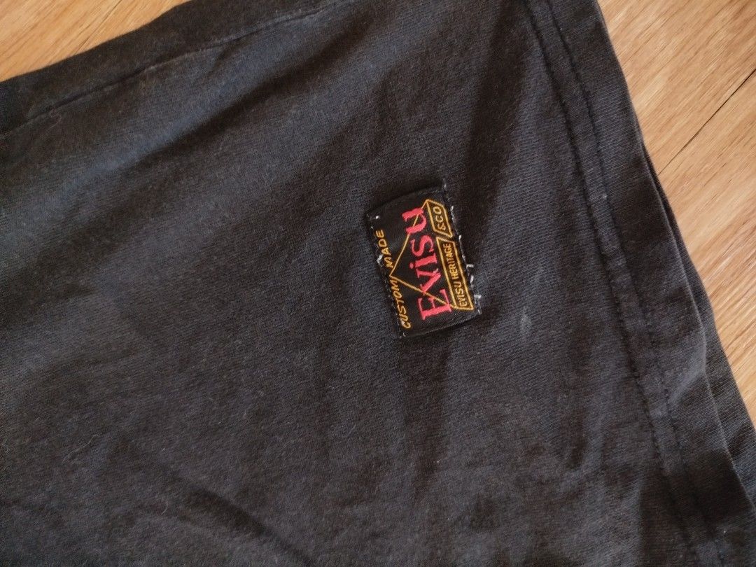 EVISU "Craft Pride" T-Shirt (Category: Tshirts & Polo Shirts ) located in Quezon City. Submitted by y2k_thriftkid (Listing ID 1461404370, Image 3). Description: - Authentic Black Evisu T-shirt - Iconic "Evisu" logo and "Craft Pride" text - Small Evisu tag detail on sleeve - Proudly Made in Japan - Ideal for everyday casual wear.