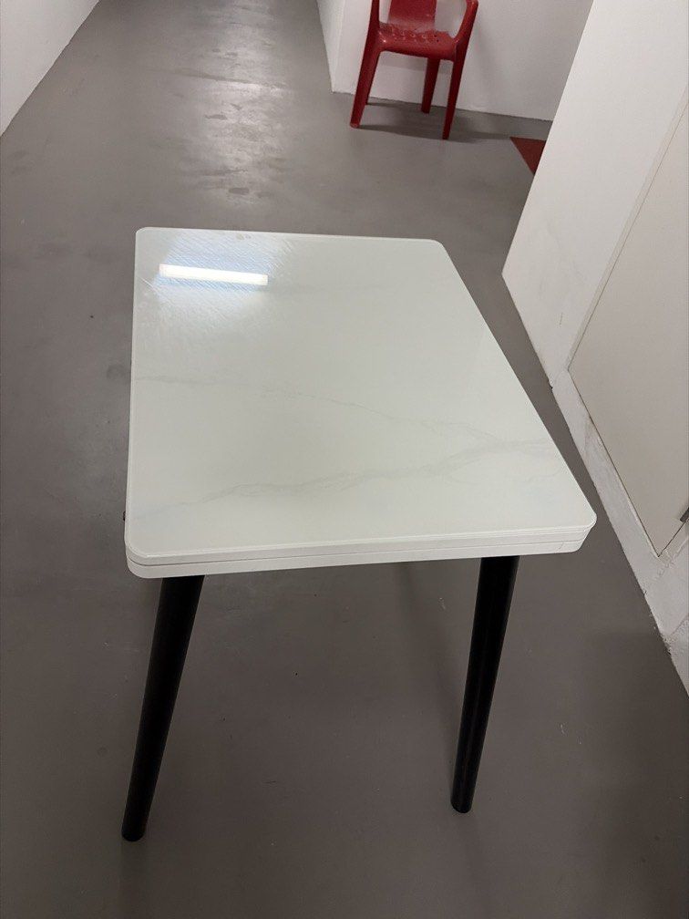 Extendable Dining Table (Category: Tables & Sets) located in Singapore. Submitted by seller24 (Listing ID 1448583753, Image 3). Description: - Extendable dining table - White laminate top Dimensions refer to the last pic - Sturdy black legs - Dimensions: 70cm (width) x 75cm (height) - Extends to 110cm (length) - Ideal for small spaces needing occasional extra seating - Easy to clean surface - bought online but didn’t fit into my renovation theme 