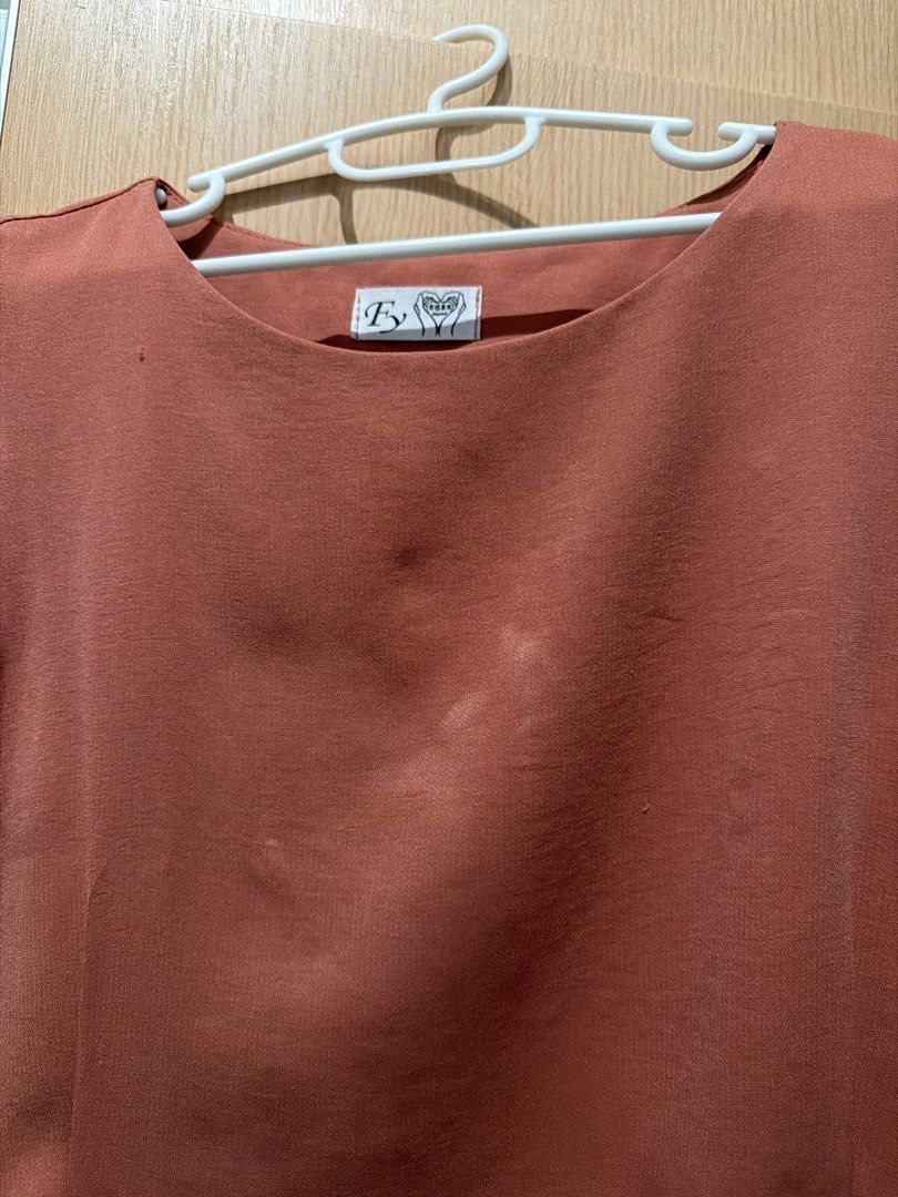 EY Sleeveless Top - Rust Orange (Category: Sleeveless) located in Taguig. Submitted by gabgabie (Listing ID 1461490040, Image 2). Description: - Rust orange sleeveless top - Round neckline - Fabric with a slight sheen - Faint marks on front (please check photos) - Side slits at the hem - Versatile for layering or wearing alone.
