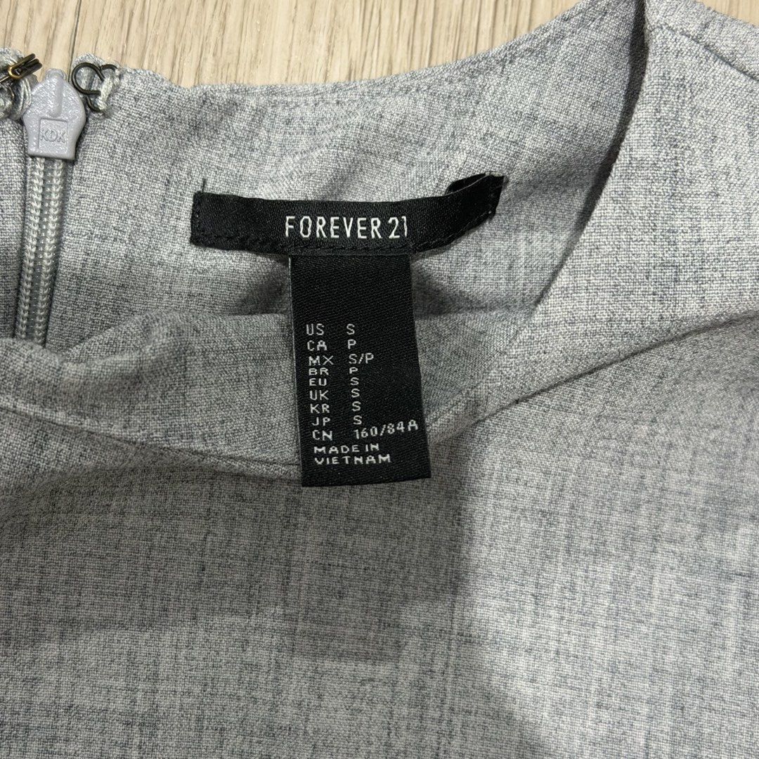 Forever 21 Grey Textured Short Sleeve Top Size S (Category: Blouses) located in Manila. Submitted by sg.21 (Listing ID 1461458593, Image 3). Description: - Forever 21 grey short sleeve top - Textured fabric - Zipper closure at the back - Small pen mark on the front (please check photos for details) Armpit 18” Length 21”.