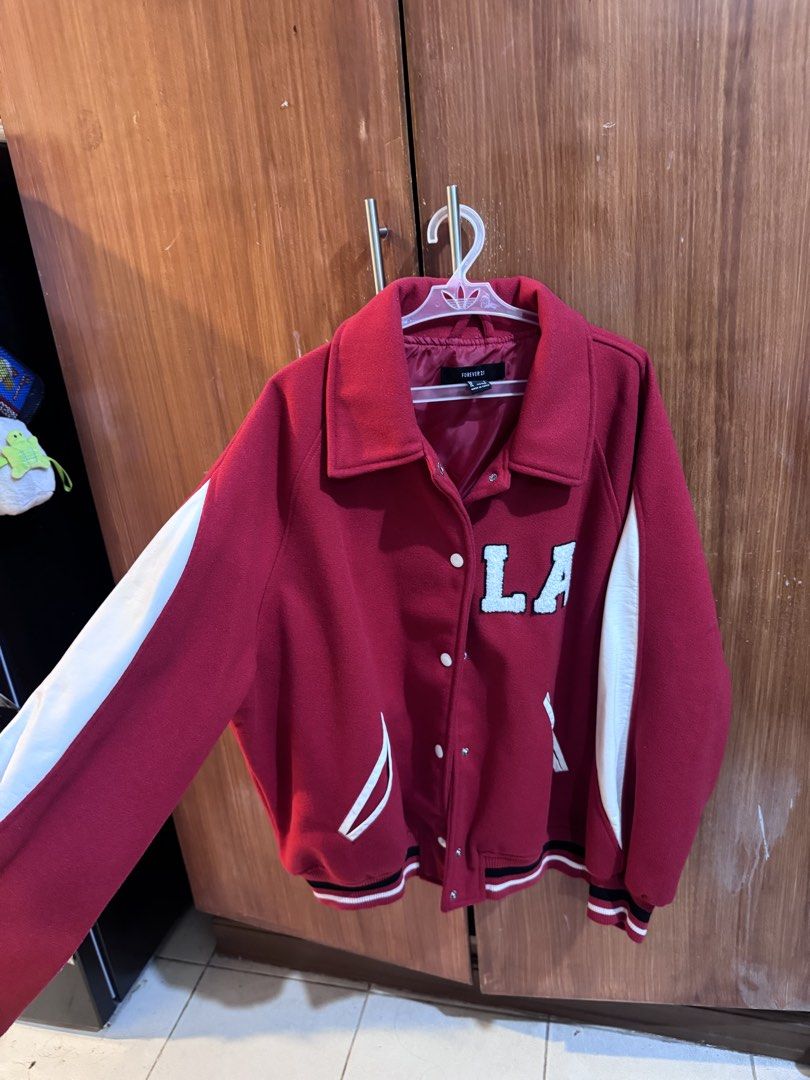 Forever 21 Red Varsity Jacket LA Established 91 (Category: Coats, Jackets and Outerwear) located in Manila. Submitted by ianventory (Listing ID 1461397124, Image 1). Description: - Forever 21 varsity jacket in red - White sleeves - 'LA' graphic on the front - 'Established 91' graphic on the back - Ribbed cuffs and hem - Button-up front - Ideal for casual wear.