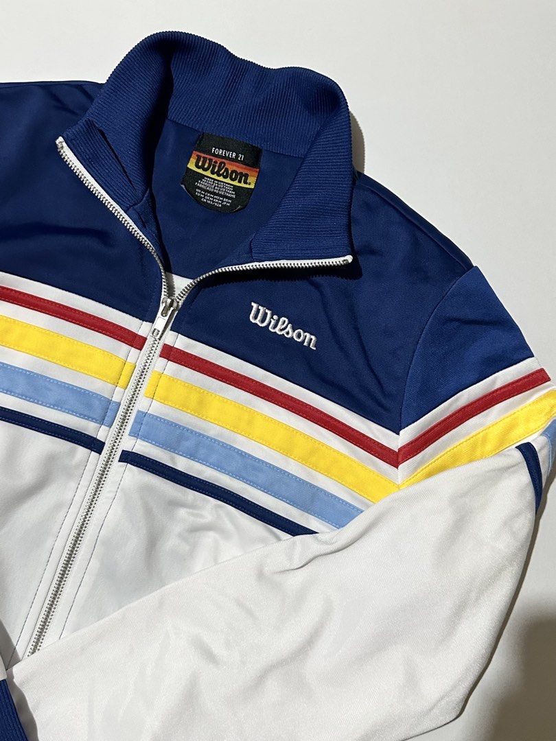 Forever 21 x Wilson Tennis Bomber Jacket (Category: Activewear) located in Manila. Submitted by reclaimed.shop (Listing ID 1461389395, Image 3). Description: Description: Forever 21 x Wilson collaboration track jacket featuring a retro tennis-inspired color-blocked design. The navy and white base is accented with colorful chevron stripes, giving it a classic sporty look with a vintage streetwear feel. ✔️ Forever 21 x Wilson collaboration piece ✔️