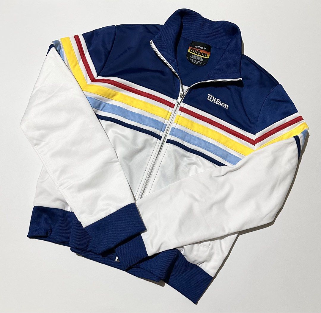 Forever 21 x Wilson Tennis Bomber Jacket (Category: Activewear) located in Manila. Submitted by reclaimed.shop (Listing ID 1461389395, Image 2). Description: Description: Forever 21 x Wilson collaboration track jacket featuring a retro tennis-inspired color-blocked design. The navy and white base is accented with colorful chevron stripes, giving it a classic sporty look with a vintage streetwear feel. ✔️ Forever 21 x Wilson collaboration piece ✔️