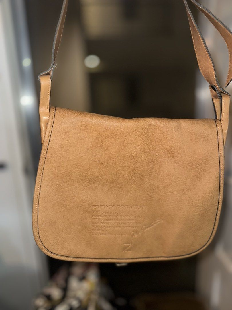 Funky Project Leather Shoulder Bag Tan (Category: Shoulder Bags) located in Mandaluyong City. Submitted by TheWeekendProject (Listing ID 1461517932, Image 2). Description: - Tan leather shoulder bag from Funky Project - Features a flap closure - Adjustable strap for comfortable wear - Embossed logo and text detail on the front - Ideal for everyday use and carrying essentials - Great for casual outings.